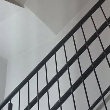 Guarda-corpo preto de barras retas numa escada branca